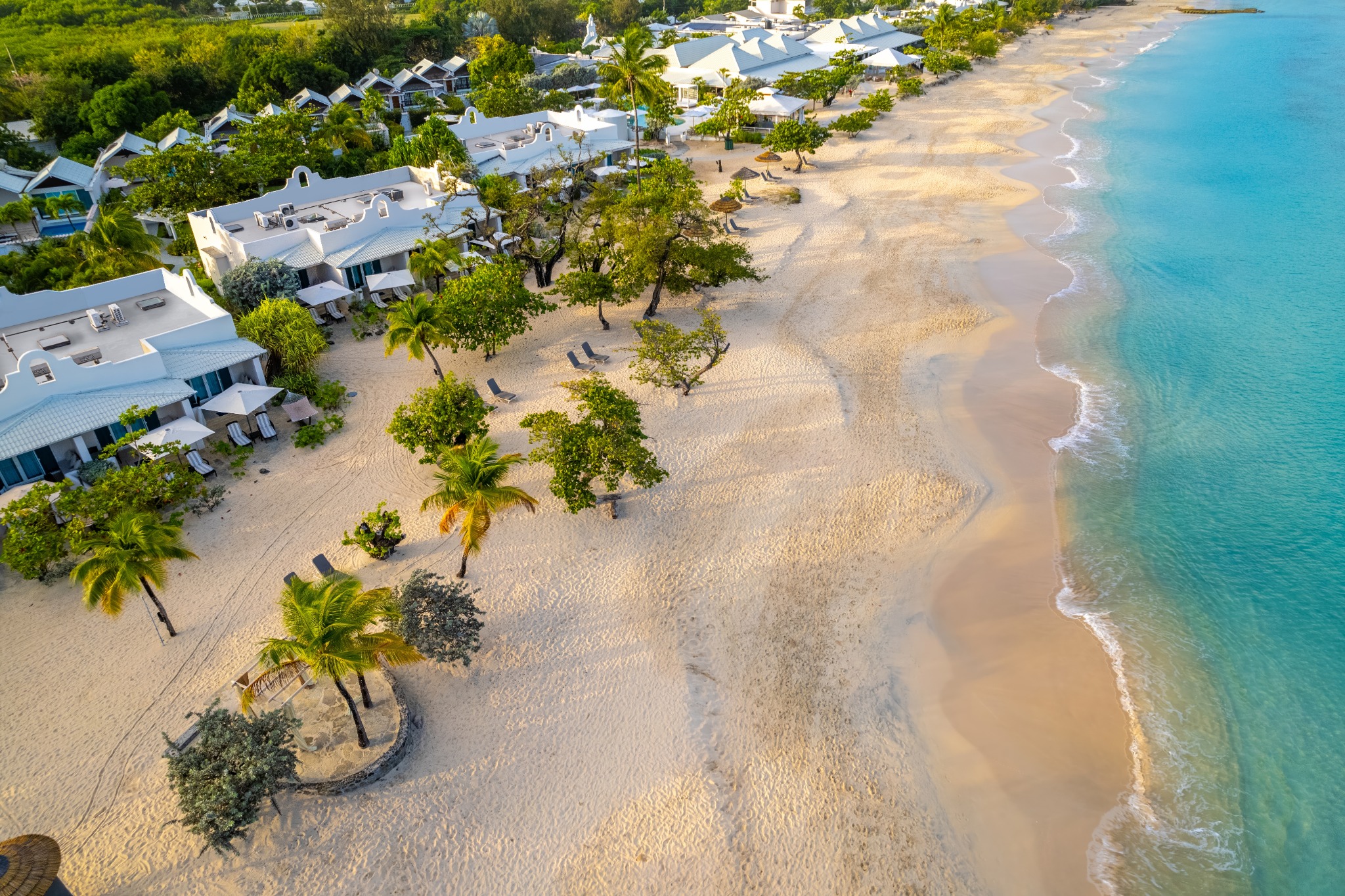 Aerial view of beachfront villas along turquoise water
