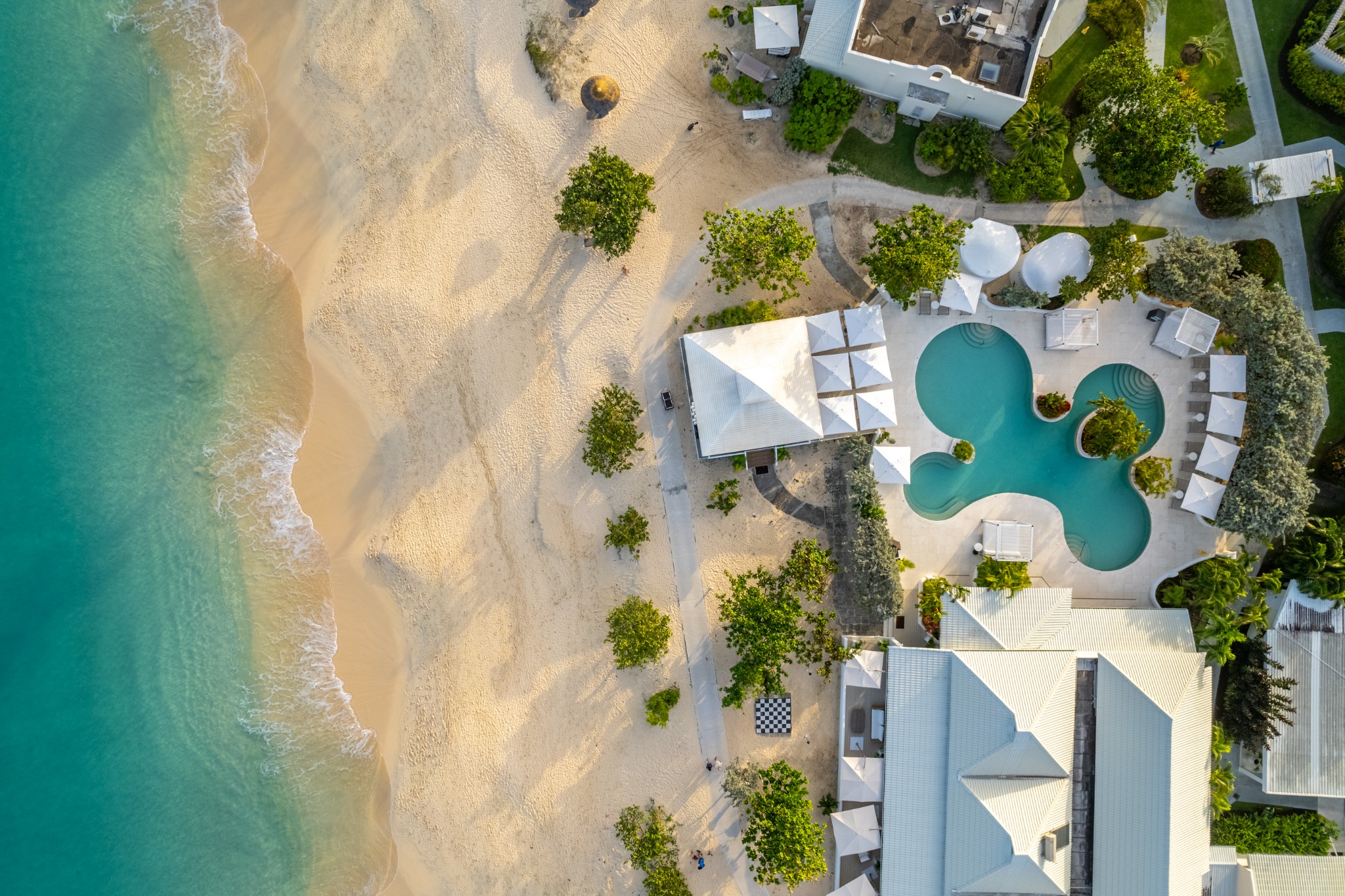 Overhead aerial of a resort pool terrace with loungers
